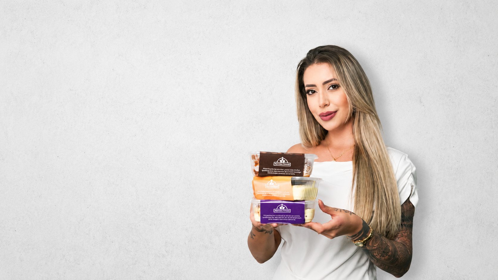 Cliente da Delícias Fitness segurando marmitas fitness com tampas coloridas